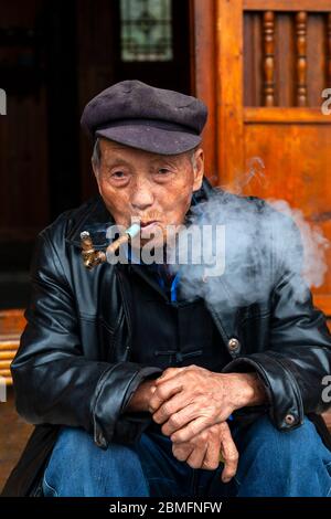 Un homme âgé avec son tuyau. Il est de la minorité Gejia. Village de Matang, région de Kaili, province de Guizhou, Chine Banque D'Images