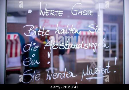 09 mai 2020, Mecklembourg-Poméranie occidentale, Kühlungsborn: Dans le restaurant 'Buhne 8', les instructions pour les mesures de protection de la couronne sont écrites sur un panneau de verre devant la terrasse avec les mots 'Dear guests! Veuillez respecter les règles de distance ! Vous allez être placé. » Les restaurants de Mecklembourg-Poméranie occidentale peuvent servir les clients de nouveau dans des conditions d'hygiène strictes et moins de sièges en raison des mesures de protection de la couronne. Pendant plusieurs semaines, les restaurants de toute l'Allemagne ont été fermés en raison du virus corona. Photo: Jens Büttner/dpa-Zentralbild/dpa Banque D'Images