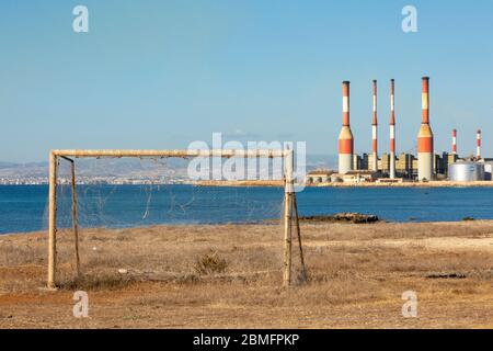 Anciens poteaux de but avec la centrale électrique de Dhekelia en arrière-plan, baie de Dhekelia, Chypre Banque D'Images