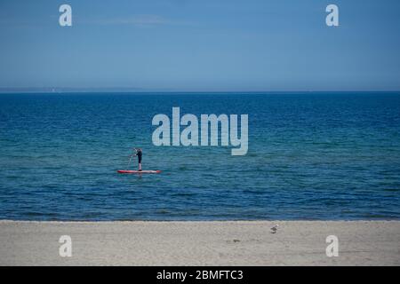 Timmendorfer Strand, Allemagne. 09e mai 2020. Un homme glisse sur l'eau sur une planche de surf sur la plage de Niendorf. Crédit : Gregor Fischer/dpa/Alay Live News Banque D'Images