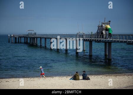 Timmendorfer Strand, Allemagne. 09e mai 2020. Les visiteurs s'assoient dans le sable en face de la jetée fermée sur la plage de Niendorf. Crédit : Gregor Fischer/dpa/Alay Live News Banque D'Images