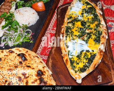 Déjeuner ou dîner traditionnel turc autoyhentique : kebab avec riz et légumes, épinards et pide d'œufs, pain plat pita et purée de lavaque ou de laves chaudes Banque D'Images