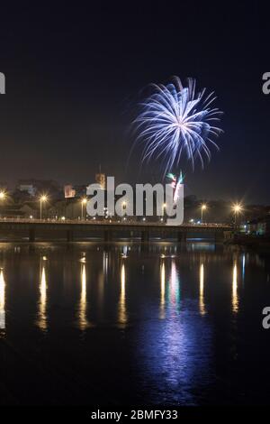 Soirée Guy Fawkes / feu d'artifice de nuit Bonfire à Lancaster se reflétant dans la rivière Lune Banque D'Images