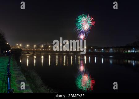 Soirée Guy Fawkes / feu d'artifice de nuit Bonfire à Lancaster se reflétant dans la rivière Lune Banque D'Images