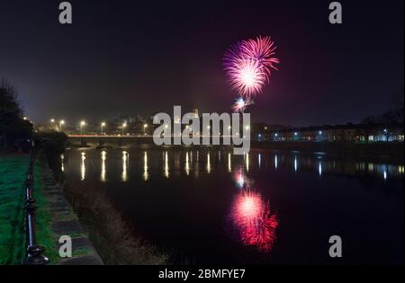 Soirée Guy Fawkes / feu d'artifice de nuit Bonfire à Lancaster se reflétant dans la rivière Lune Banque D'Images