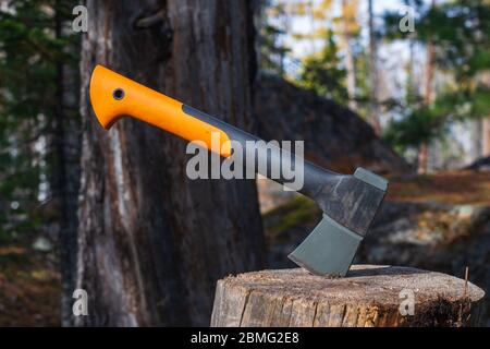 Hache touristique sur une souche dans une forêt d'été. Hacher du bois avec une hache. Camping touristique. Jour d'été. Le concept de l'aventure et de la liberté Banque D'Images