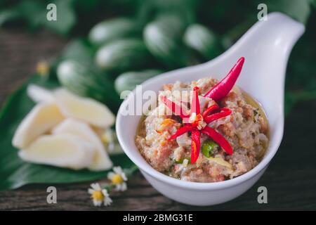 Roe de crabe au Chili de noix de coco trempez avec des légumes sur fond de bois Banque D'Images