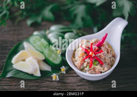 Roe de crabe au Chili de noix de coco trempez avec des légumes sur fond de bois Banque D'Images