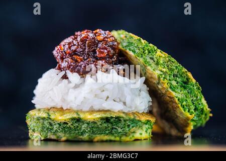 Pâte de piment épicée avec riz vapeur et œuf frit avec hochet grimpant sur fond sombre Banque D'Images