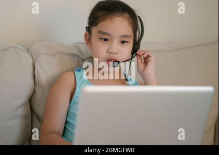 asiatique fille élève porter casque regarder webinar écouter cours en ligne communiquer par conférence appel vidéo. . Homeschooling et l'apprentissage à distance, onli Banque D'Images