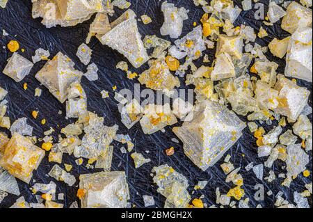 Gros plan de cristaux de sel de citron jaune sur un panneau d'ardoise Banque D'Images