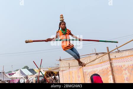 Jeune fille exécutant acrobaties dans corde serrée et l'équilibrage avec bambou à la Foire de Pushkar Banque D'Images