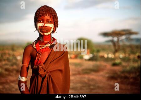 Jeune fille Hamer au coucher du soleil dans le village de Gabo. Banque D'Images
