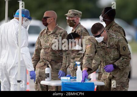 SPC. Nicholas Cisneros passe un écouvillon nasal prélevé sur un patient pendant que l'équipe mobile de test de la Garde nationale du Texas (MTT) teste le coronavirus dans une clinique de conduite gratuite dans la petite ville de Taylor, au centre du Texas. Banque D'Images