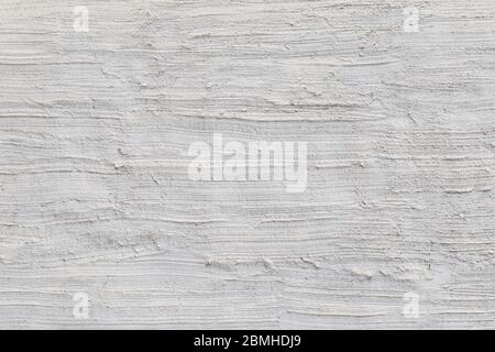 Gros plan d'un mur en béton ou en pierre enduit et rugueux peint en blanc ou gris clair, texture stuc faite à la main. Fond texturé plein format. Banque D'Images
