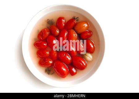 Tomates rouges fermentées sur une plaque blanche isolée sur un fond blanc. Plats végétariens. Tomates salées. Tomates biologiques marinées. Fermenté maison Banque D'Images
