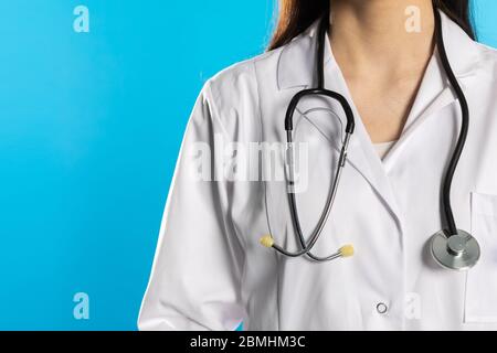Stéthoscope sur le fond de la silhouette d'un médecin vêtu d'un manteau d'hôpital. Banque D'Images
