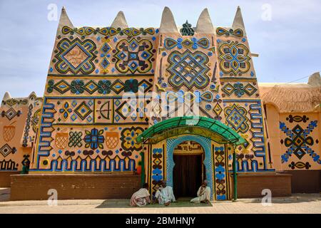 Les personnes assises à l'ombre près de la porte d'entrée du palais Bauchi décoré avec des éléments traditionnels de Hausa. Banque D'Images