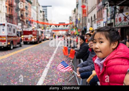 Chinatown, New York, Etats-Unis - février 8 2020 : enfants et adultes chinois asiatiques pendant la parade de l'année lunaire dans le costume et les drapeaux applaudissent Banque D'Images