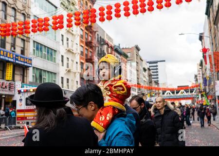 Chinatown, New York, Etats-Unis - février 8 2020 : enfants et adultes chinois asiatiques pendant la parade de l'année lunaire dans le costume et les drapeaux applaudissent Banque D'Images