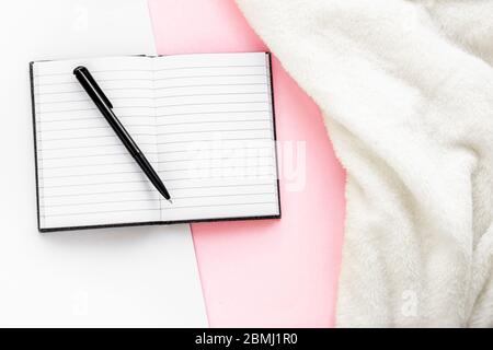 Placotez un espace de travail confortable avec des plis chauds et un bloc-notes. Concept de travail et d'écriture à domicile. Vue de dessus. Banque D'Images