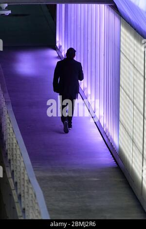 Un homme marchant seul à travers un passage souterrain piéton dans un centre-ville Banque D'Images