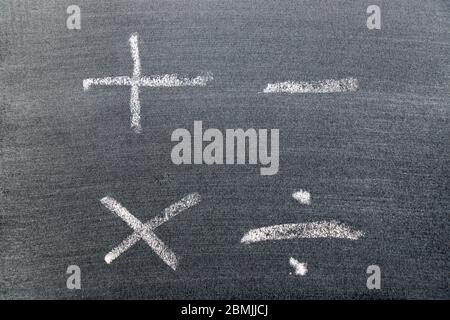 Dessin à la main blanc en forme de symbole mathématique (plus, moins, multiplier, diviser) sur fond noir Banque D'Images