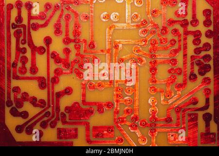 Circuit imprimé fait main avec pistes soudées rouges. Arrière-plan industriel. Textolite avec soudure Banque D'Images
