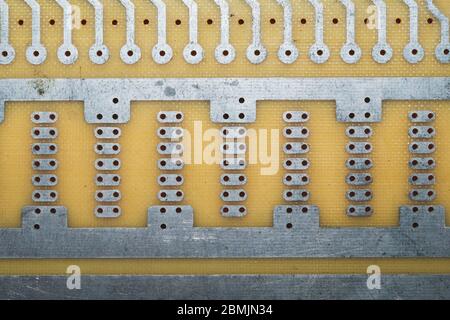 Carte de circuit imprimé sans éléments. Surface en textolite. Modèle pour souder le circuit. Fond perforé Banque D'Images