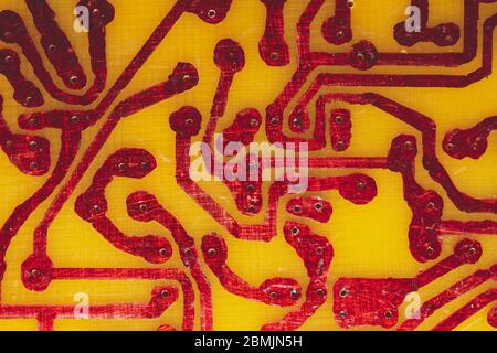 Circuit imprimé fait main avec pistes soudées rouges. Arrière-plan industriel. Textolite avec soudure Banque D'Images