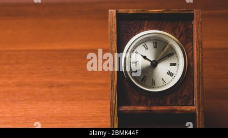 Horloge rétro en bois. Horloge vintage carrée avec cadran rond. Table en bois. Espace pour copier Banque D'Images