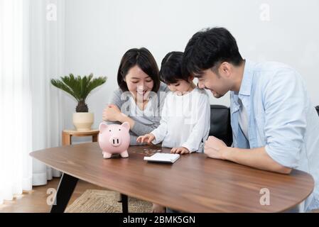 Les jeunes parents et mères asiatiques économisent de l'argent avec leur fille Banque D'Images