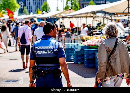 Rotterdam, pays-Bas. 09e mai 2020. Un policier parcourt le marché pour voir que les gens suivent les règles établies pour eux contre la propagation du covid 19.a Rotterdam, alors que les marchés s'ouvrent à nouveau, des foules se rassemblent tandis que les forces de l'ordre tournent pour s'assurer que les mesures sont respectées pour arrêter la propagation du virus corona. Crédit : SOPA Images Limited/Alamy Live News Banque D'Images