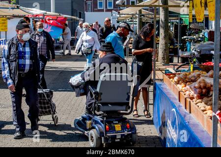 Rotterdam, pays-Bas. 09e mai 2020. Un homme porte un masque facial lorsqu'il marche à travers le marché.a Rotterdam, alors que les marchés s'ouvrent à nouveau, des foules se rassemblent tandis que les forces de l'ordre tournent pour s'assurer que des mesures sont observées pour arrêter la propagation du virus corona. Crédit : SOPA Images Limited/Alamy Live News Banque D'Images