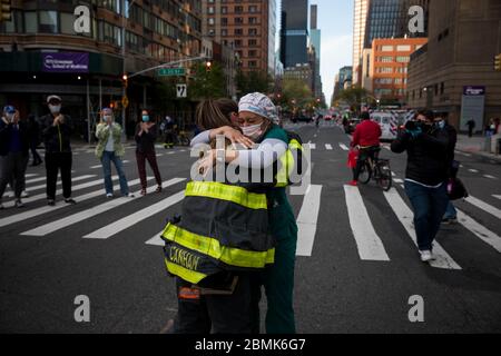 (200510) -- NEW YORK, le 10 mai 2020 (Xinhua) -- Un pompier épouse Samantha Giambalvo (R), une infirmière itinérante de l'Alabama qui travaille à New York depuis avril 6, tandis que les pompiers et les résidents apprécient les travailleurs de la santé du NYU Langone Medical Center, dans le contexte de l'épidémie de COVID-19 à New York, aux États-Unis, le 9 mai 2020. Le nombre de cas de COVID-19 aux États-Unis a atteint 1,300,079 à 3 h 32 (1932 GMT) samedi, selon le Centre for Systems Science and Engineering (CSSE) de l'Université Johns Hopkins. Pendant ce temps, le nombre de morts de la maladie dans le cou Banque D'Images