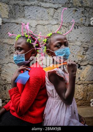 Nairobi, Kenya. 09e mai 2020. Martha APISA (à gauche), âgée de 12 ans, et Stacy Ayuma (à droite), voisine de 8 ans, sont vues à l'aide de leurs tresses de cheveux pour sensibiliser et ressentir le virus Corona pendant la pandémie. Le Kenya a enregistré 649 cas confirmés, 207 cas de rétablissement et 30 décès dus à la maladie de Covid 19. Crédit : SOPA Images Limited/Alamy Live News Banque D'Images