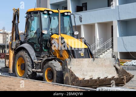 Kharkiv, Ukraine, 29 mars 2020 : pelle hydraulique JCB garée à l'extérieur. Le tracteur jaune sale sur le chantier. Véhicule européen, bulldozer avec bu Banque D'Images