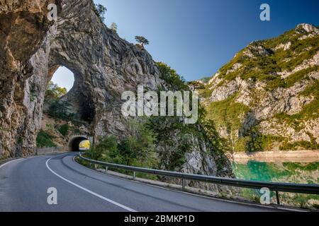 Ouverture naturelle dans la roche au-dessus du tunnel routier au-dessus du lac Piva (Pivsko jezero), lac artificiel près de Pluzine, Monténégro, Europe du Sud-est Banque D'Images