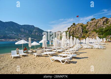 plage en mer par temps sans nuages. Nombreux transats blancs et parasols compliqués Banque D'Images