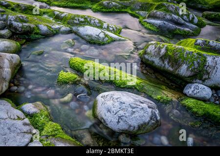 Longue exposition d'une rivière avec des rochers et de la mousse Banque D'Images