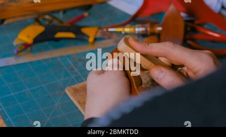 Professionnel hommes skinner, tanner travailler avec véritable cuir ceinture en atelier, studio. Et le travail du cuir fait main concept Banque D'Images