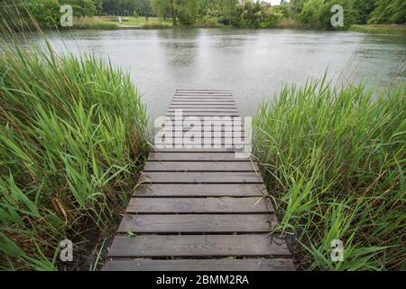 Jetée sur l'eau dans un parc public par temps pluvieux Banque D'Images