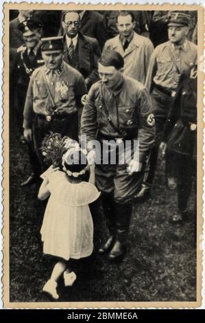 Une petite fille offre un bouquet de fleurs a Adolf Hitler (1889-1945), chancellier allemand et leader et responsable du parti National Socialiste (nazi) Banque D'Images