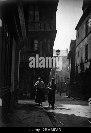 Un couple de Traailleurs marchant dans une rue de Rouen en Normandie - 1920 environ (UN couple de travailleurs marchant dans une rue de Rouen, Normandie, ca 1 Banque D'Images