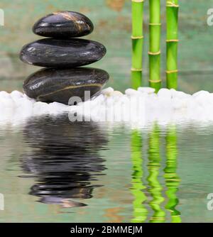 Jardin zen japonais avec des pierres empilées dans l'eau mise en miroir Banque D'Images