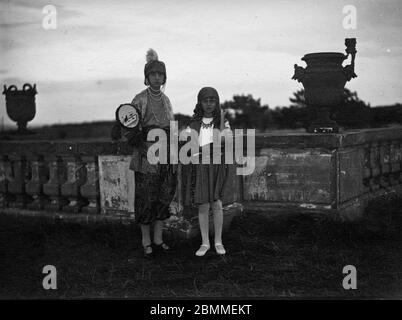 Portrait de deux petites filles de la bourgeoisie parisienne, deguisies, l'occasion d'une tête dans le parc d'un château pres de Paris (Chantilly ?) Banque D'Images