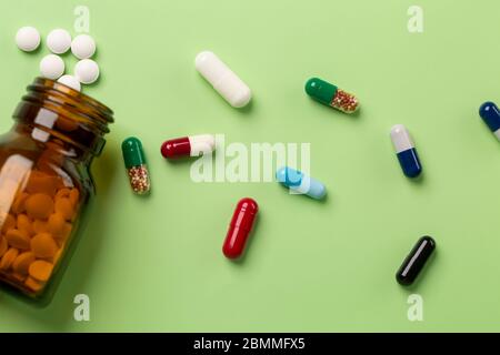 Différents médicaments. Flacons à pilules en verre. Fond vert. Banque D'Images