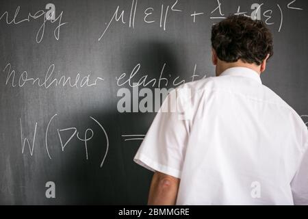 Professeur de mathématiques principal enseignant de mathématiques, écrivant sur le tableau noir pendant la classe Banque D'Images