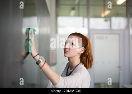 Jeune étudiant écrit sur le tableau/blackboard pendant un cours de mathématiques. Banque D'Images