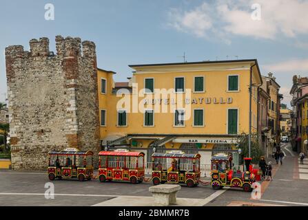 Vue sur la vieille ville de Bardolino sur les rives du lac de Garde avec la tour médiévale et les touristes sur un petit train, Vérone, Vénétie, Italie Banque D'Images